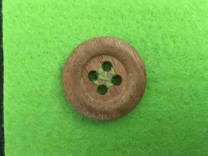 cucitura del bottone con un filo verde